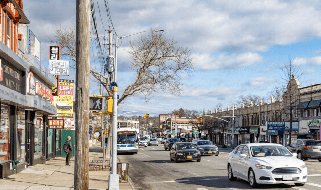 A busy street with cars and buses on the side of it.