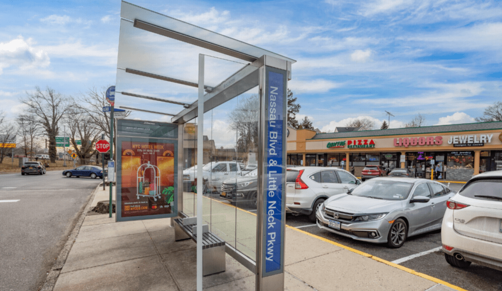 A bus stop with cars parked on the side of it.