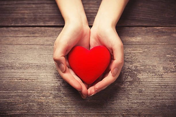 A person holding a heart in their hands.