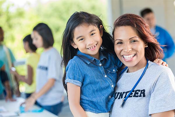 A woman and girl smiling for the camera.