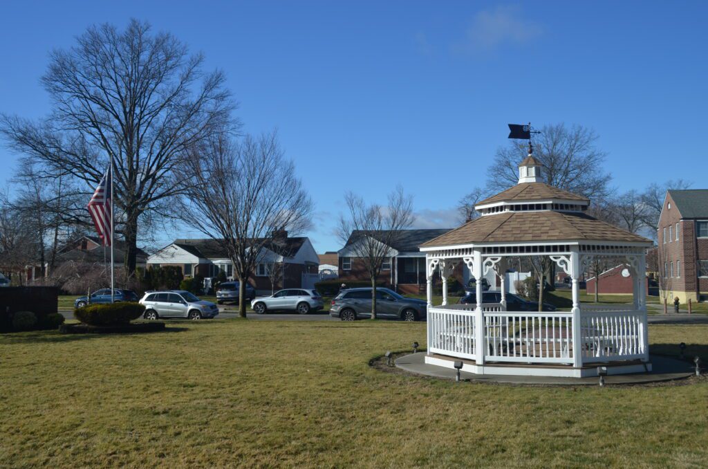 A white gazebo in the middle of a field.