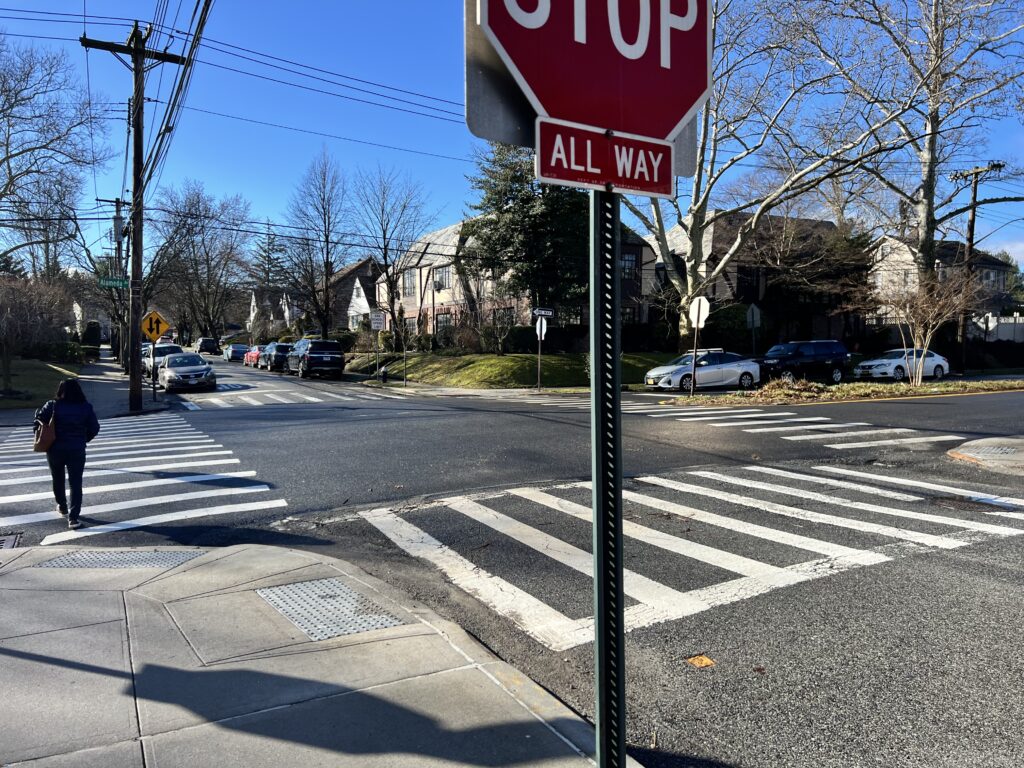 A stop sign on the corner of an intersection.