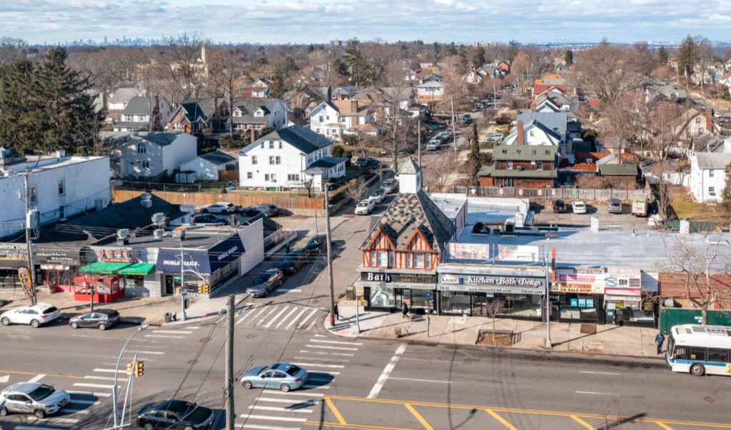 A view of a town from top with cars in the road and no large buildings